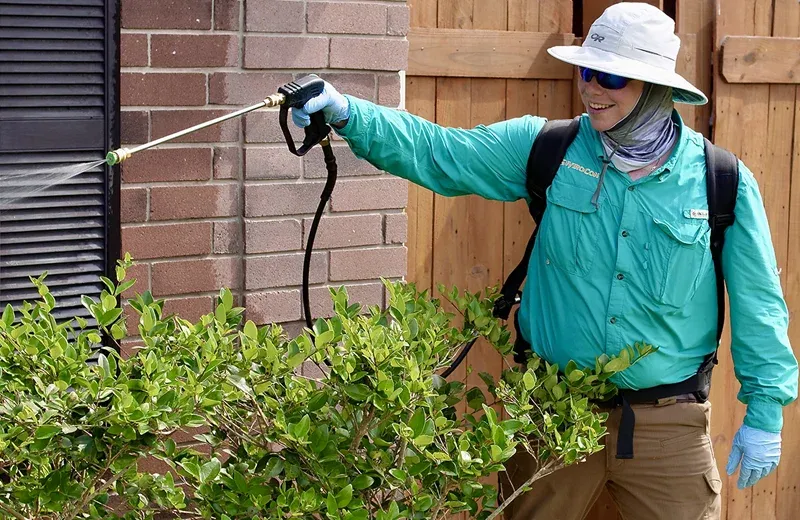 envirocon pest technician spraying outside of home