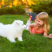 Girl with dog laying in spring grass